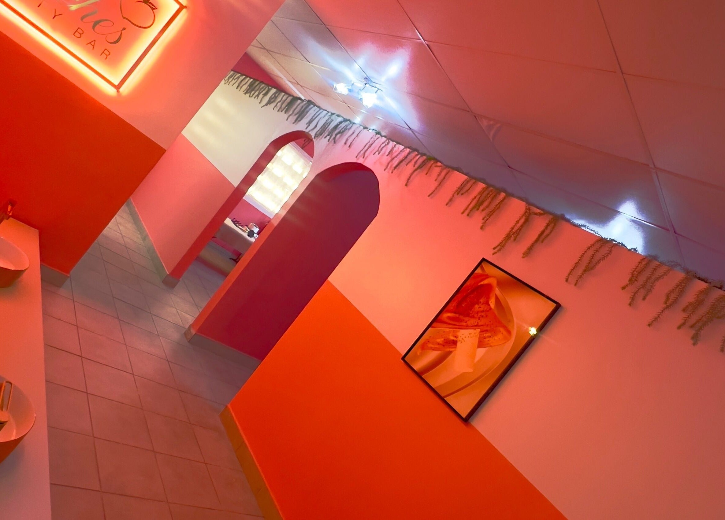 Vibrant hallway at Peaches Beauty Bar in Edenvale, Gauteng, ZA with pink lighting and elegant decor.