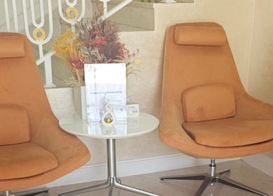 Cozy seating area at Vivo Clinic Dubai, featuring orange chairs and a modern table in Dubai, Dubai, AE.