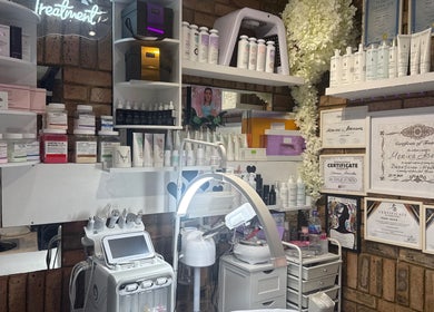 Beauty product display at Monica’s Beauty Lounge, London, England, GB with certificates and treatment devices.