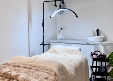 Cozy treatment room at Bespoke Beauty, Caringbah, New South Wales, AU, featuring a plush bed and modern decor.