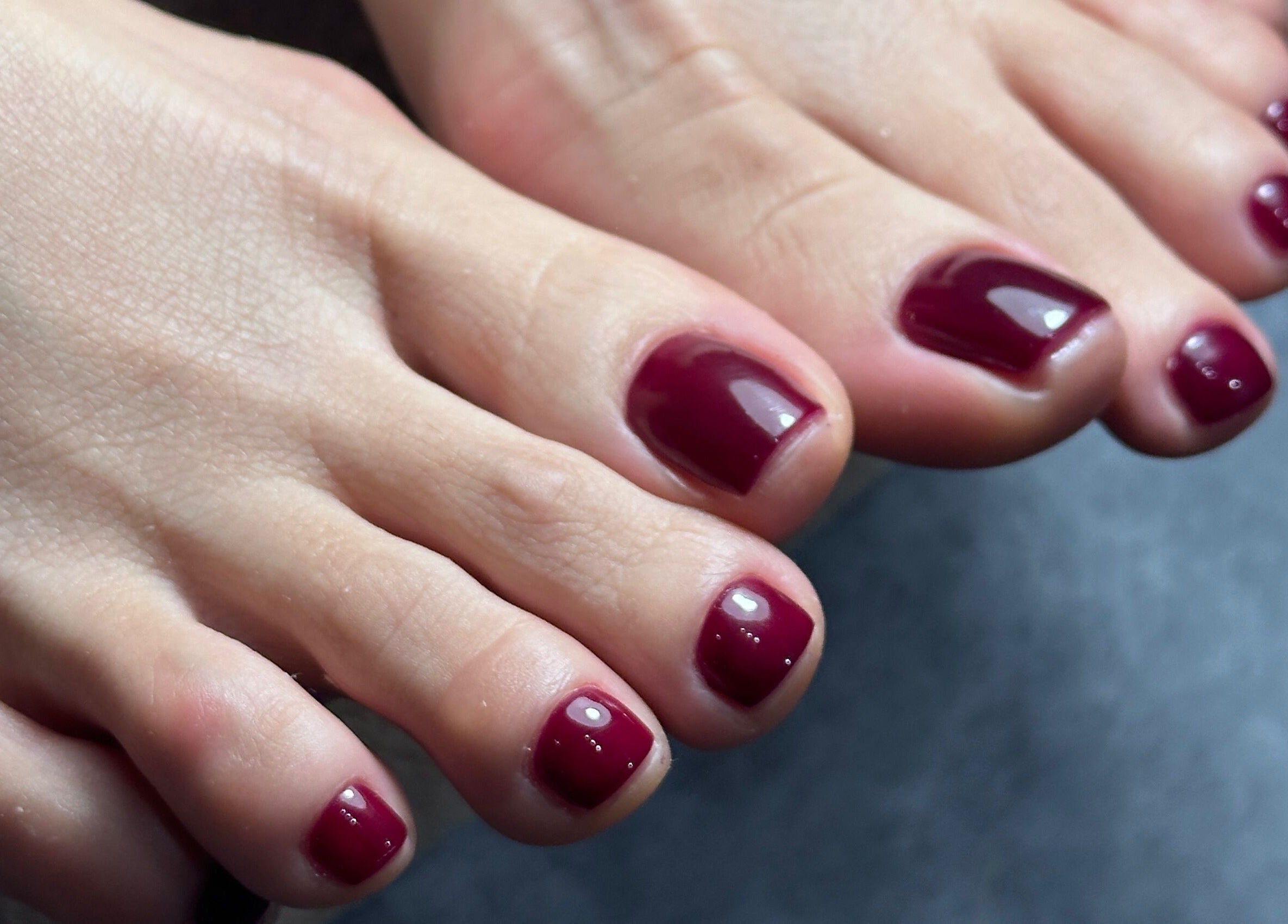 Stylish burgundy pedicure at Studio April, Melbourne, Victoria, AU, showcasing professional nail care.