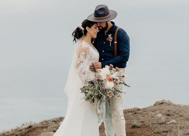 A newlywed couple embraces with scenic views at The Hair Lounge (The Salon on Princes), Dunedin, Otago Region, NZ.