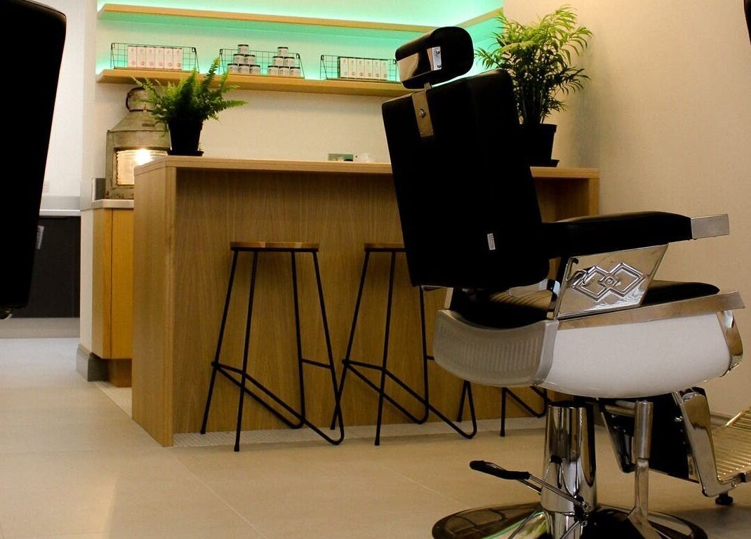 Modern salon interior at Barvello, Saint Helier, St Helier, JE, featuring sleek barber chairs and green plants.
