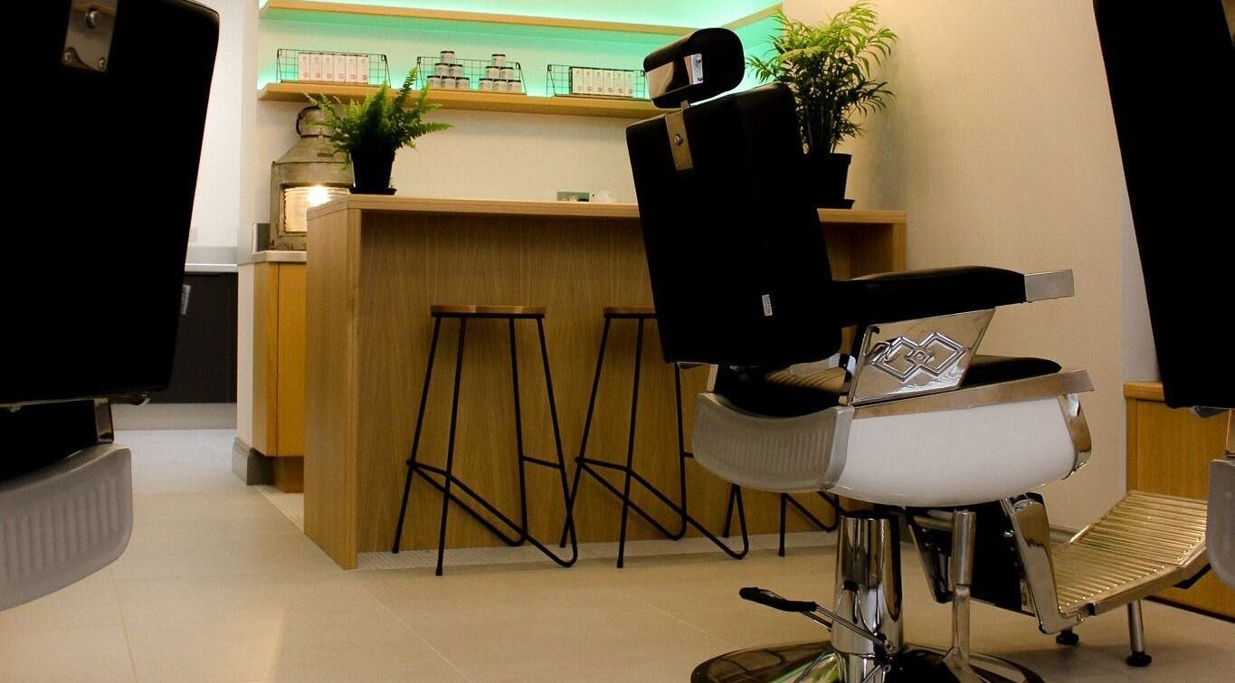 Modern salon interior at Barvello, Saint Helier, St Helier, JE, featuring sleek barber chairs and green plants.