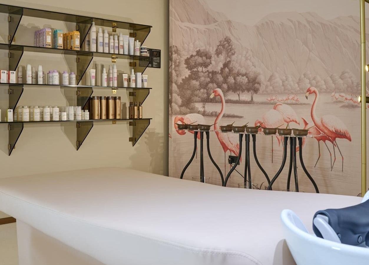 Relaxing spa room at Illustrated Nails, The Muse Boutique Hotel, Lusail featuring pink flamingo mural and shelves.