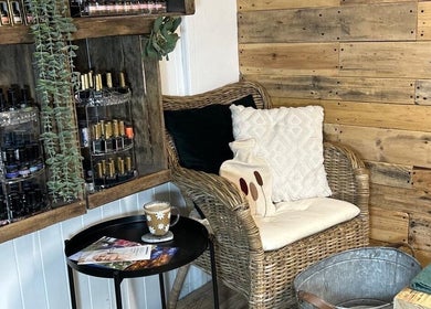 Charming nail care corner at Perfectpedi with Frenchies, Pembroke, Cymru, GB. Features cozy wicker chair, products, and decor.