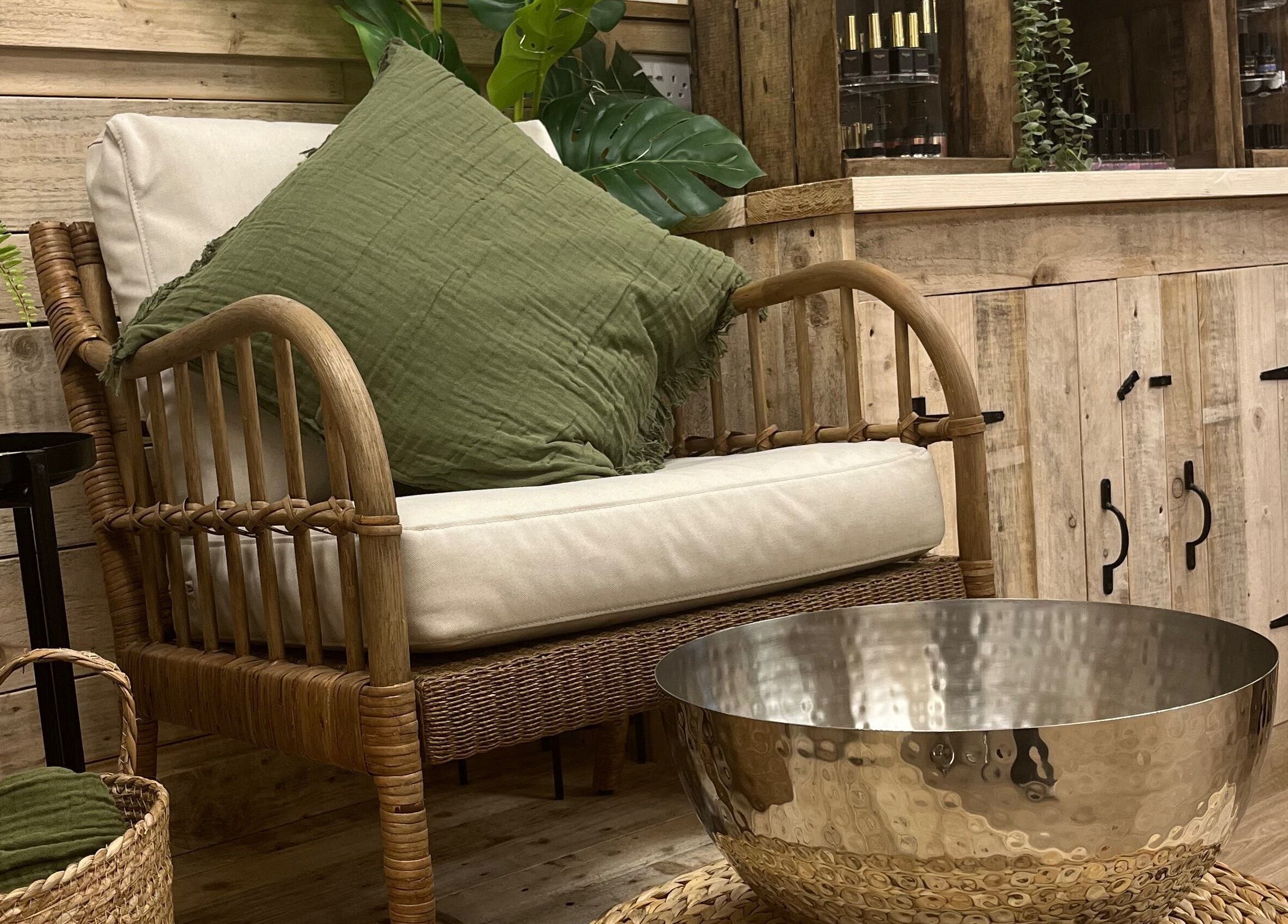 Cozy seating area at Perfectpedi With Frenchies in Pembroke, Cymru, GB, featuring a wicker chair and green cushion.
