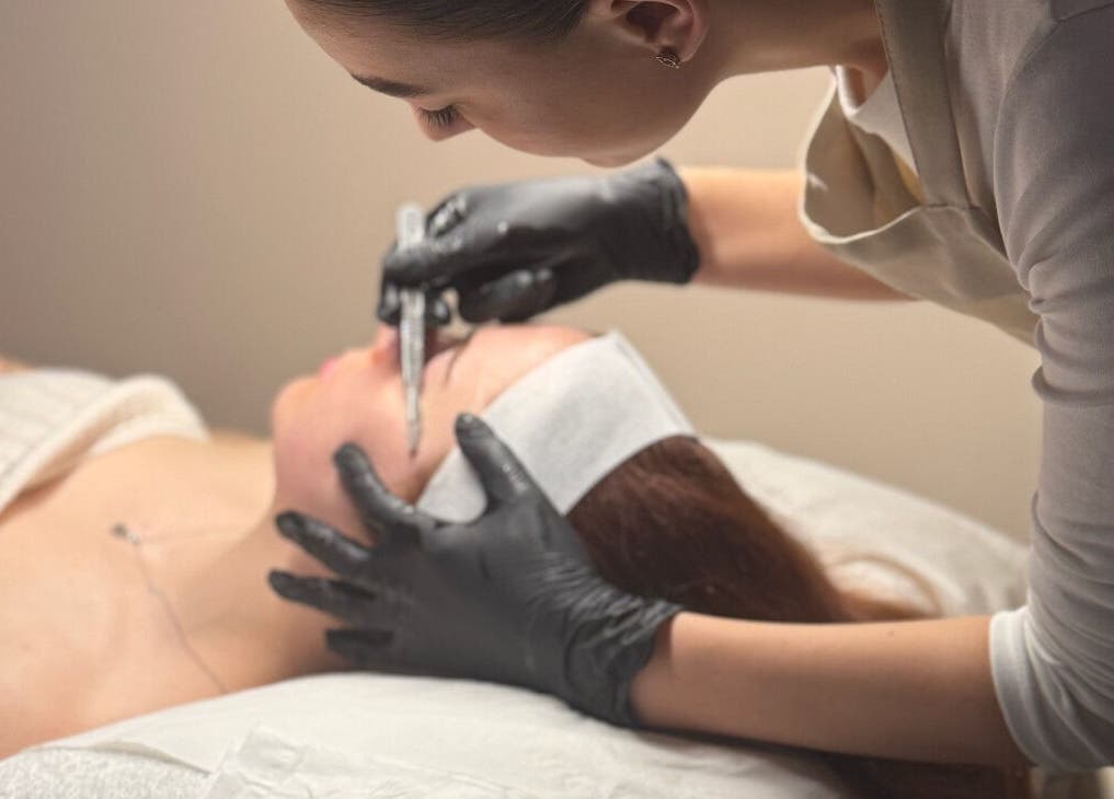 Aesthetician applies treatment at Glow Beauty, Elgin, Scotland, GB in relaxing setting.