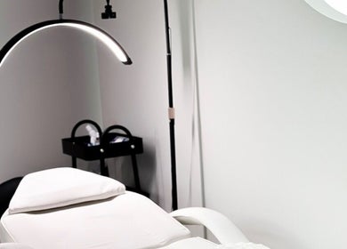 Modern treatment room at Perla Beauty Lounge, Ras Al Khaimah, AE with a luxurious white chair and sleek lighting.