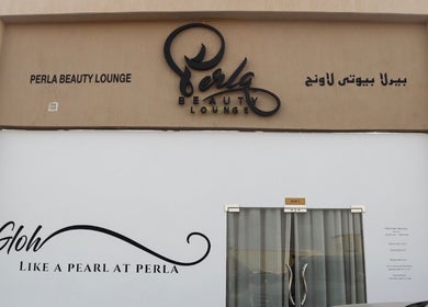 Entrance to Perla Beauty Lounge in Ras Al Khaimah, AE featuring modern signage and glass doors.