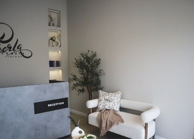 Reception area of Perla Beauty Lounge in Ras Al Khaimah, AE featuring modern decor and comfortable seating.