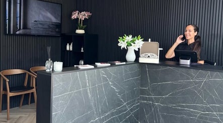 Reception area of William Foley Skin, Alderley Edge, England, GB with a smiling receptionist.