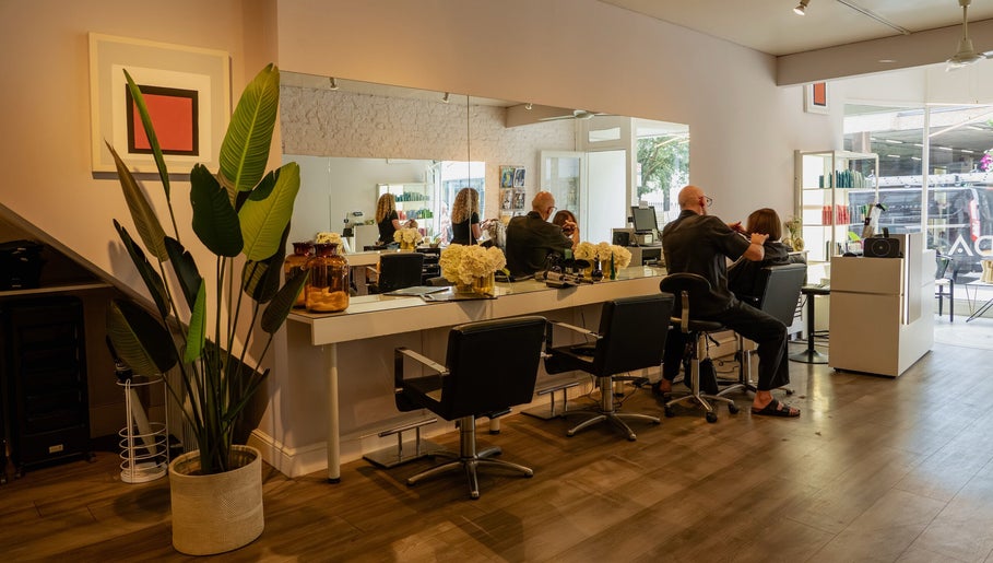 Modern interior of David Masters Salon - Richmond Bridge, Twickenham, England, GB with clients and stylists.