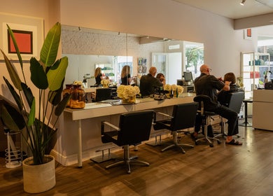 Modern interior of David Masters Salon - Richmond Bridge, Twickenham, England, GB with clients and stylists.