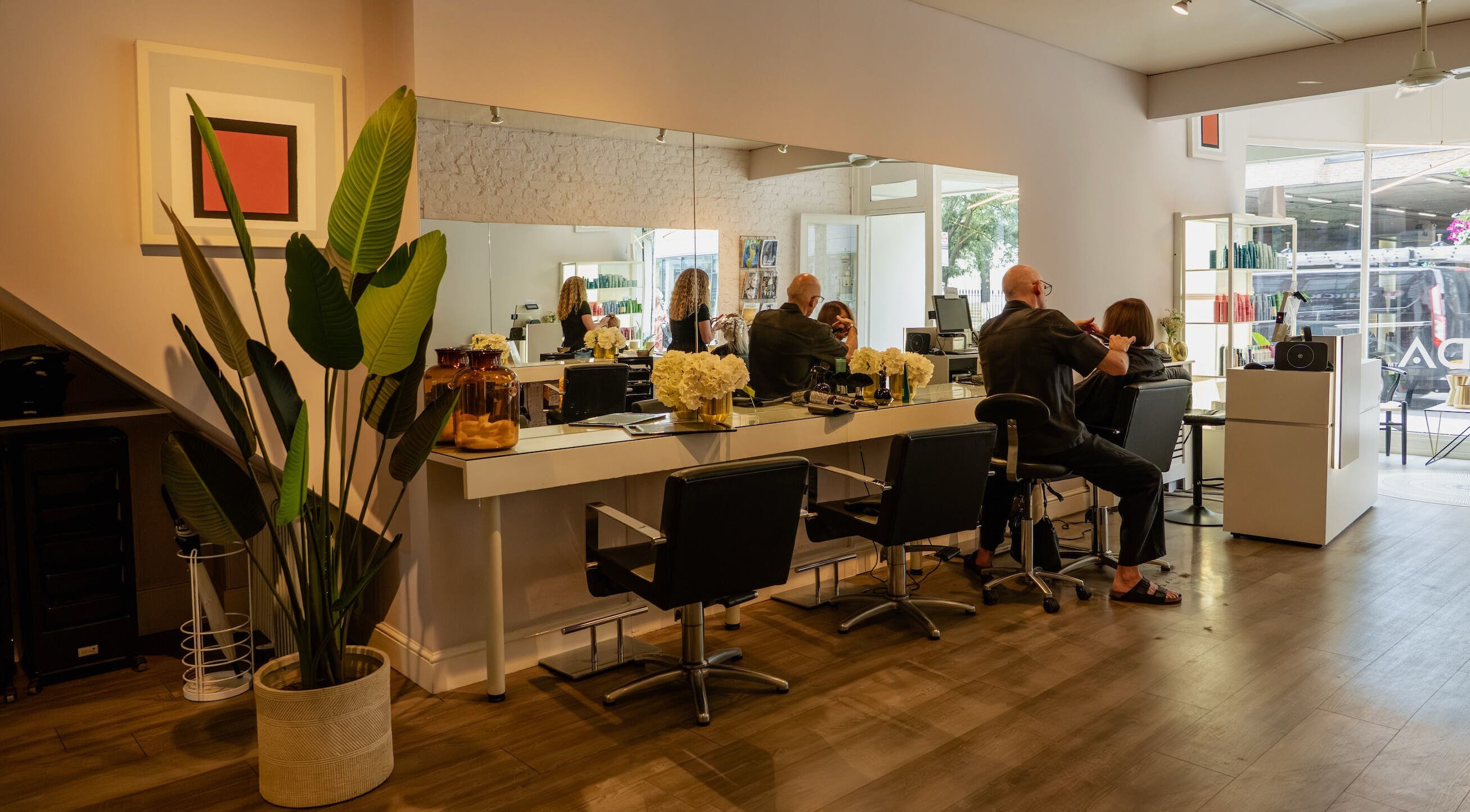Modern interior of David Masters Salon - Richmond Bridge, Twickenham, England, GB with clients and stylists.