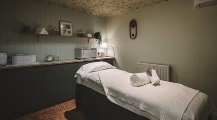 Massage room at Cecily Marlow in Marlow, England, GB featuring a cozy treatment bed and warm lighting.
