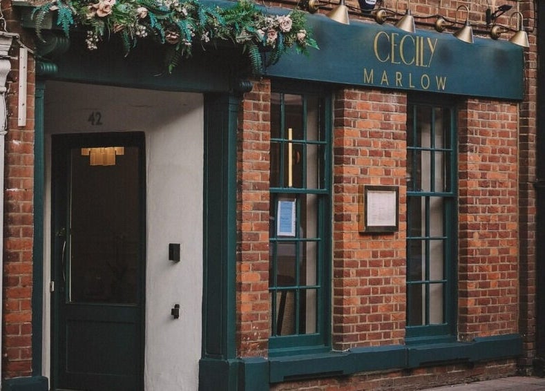 Charming brick facade of Cecily Marlow in Marlow, England, GB, with teal accents and floral decor.