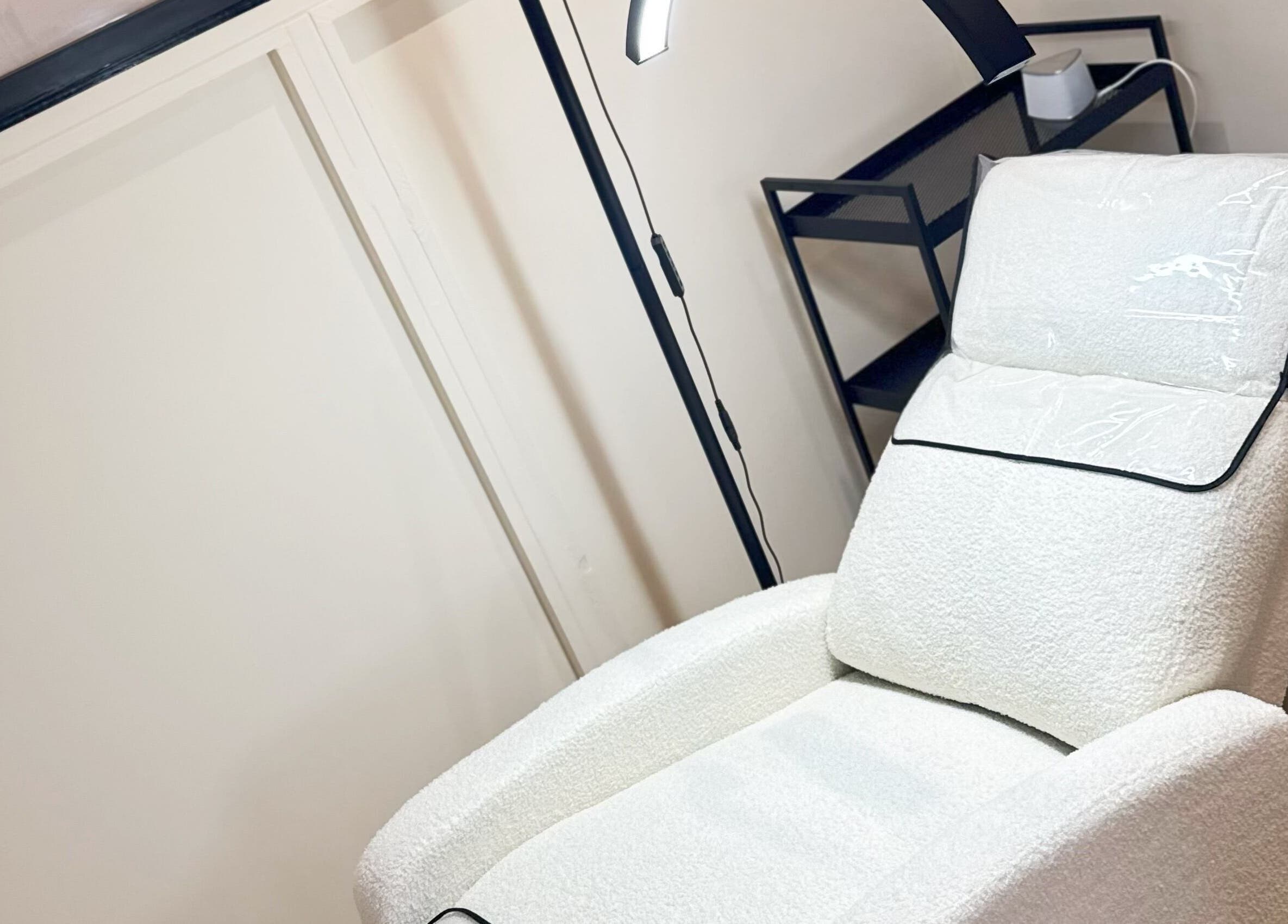 Relaxing white treatment chair at J9 Aesthetics in Harworth, England, GB, offering a tranquil wellness experience.
