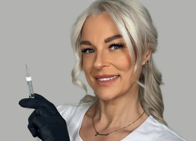 Aesthetician smiling with syringe at J9 Aesthetics, Harworth, England, GB, showcasing professional care.