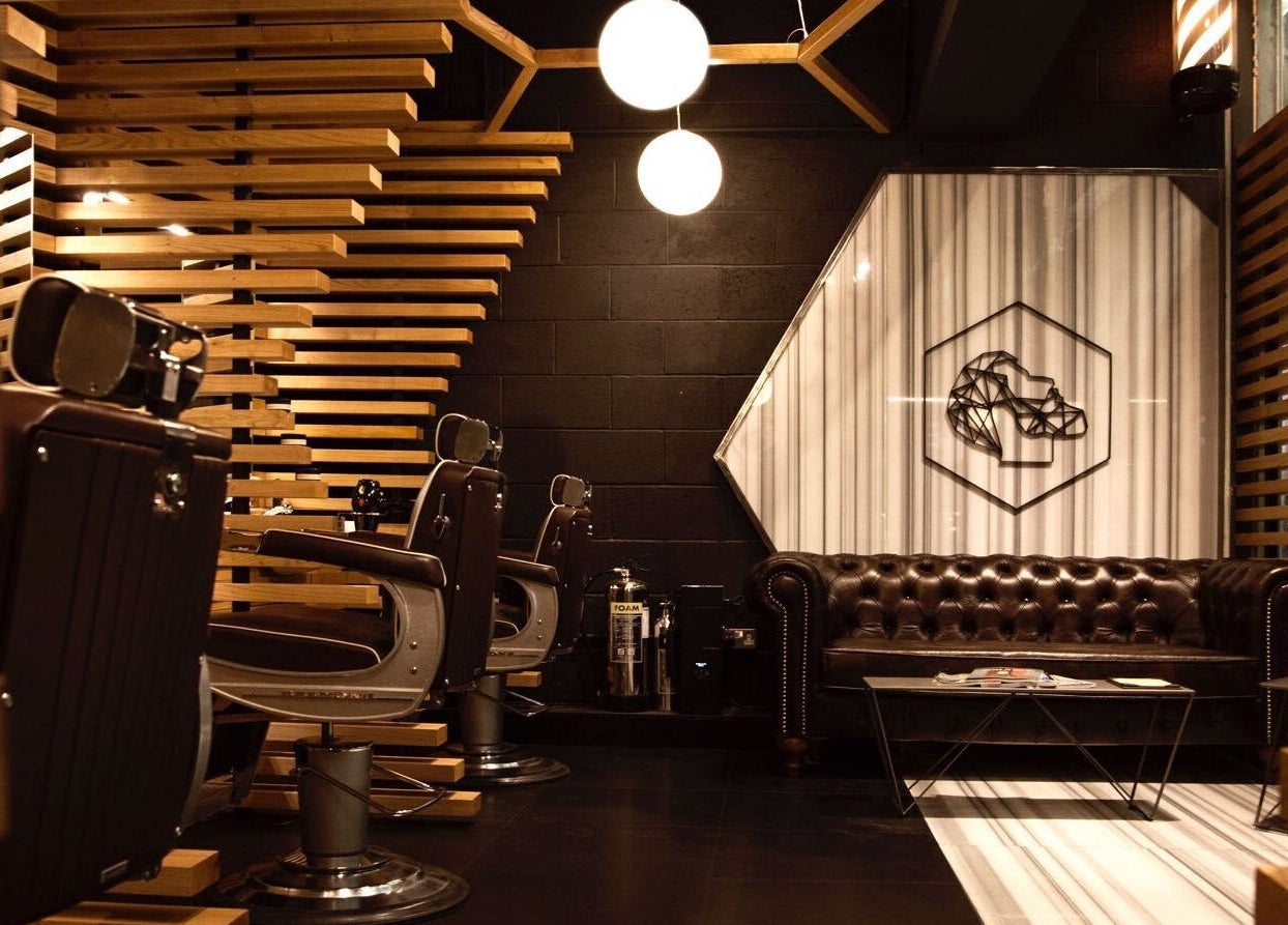 Interior of ADAM Grooming Atelier - Canary Wharf Jubilee Station, London, England, GB with leather seating and modern decor.