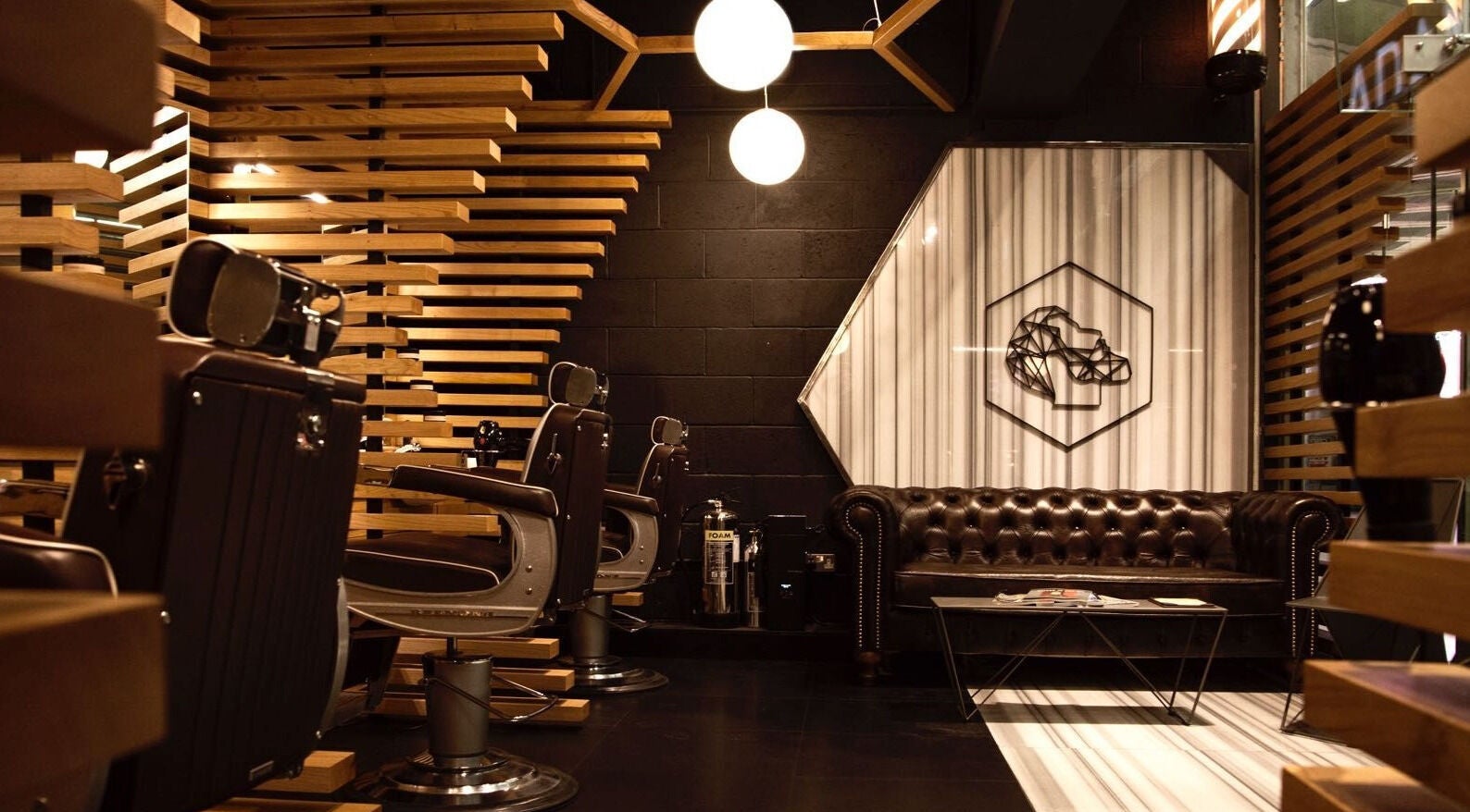 Interior of ADAM Grooming Atelier - Canary Wharf Jubilee Station, London, England, GB with leather seating and modern decor.