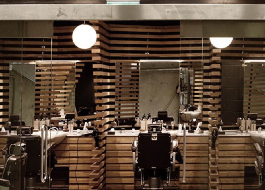 Interior of ADAM Grooming Atelier - Canary Wharf Jubilee Station in London, England, GB features sleek barber chairs.