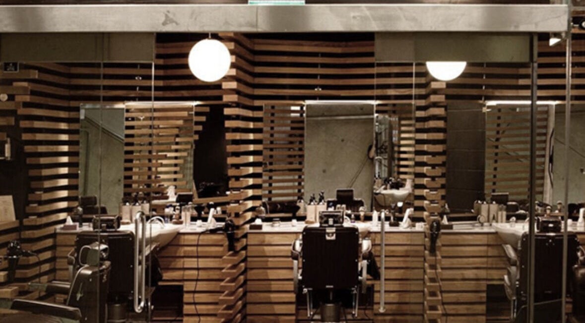 Interior of ADAM Grooming Atelier - Canary Wharf Jubilee Station in London, England, GB features sleek barber chairs.