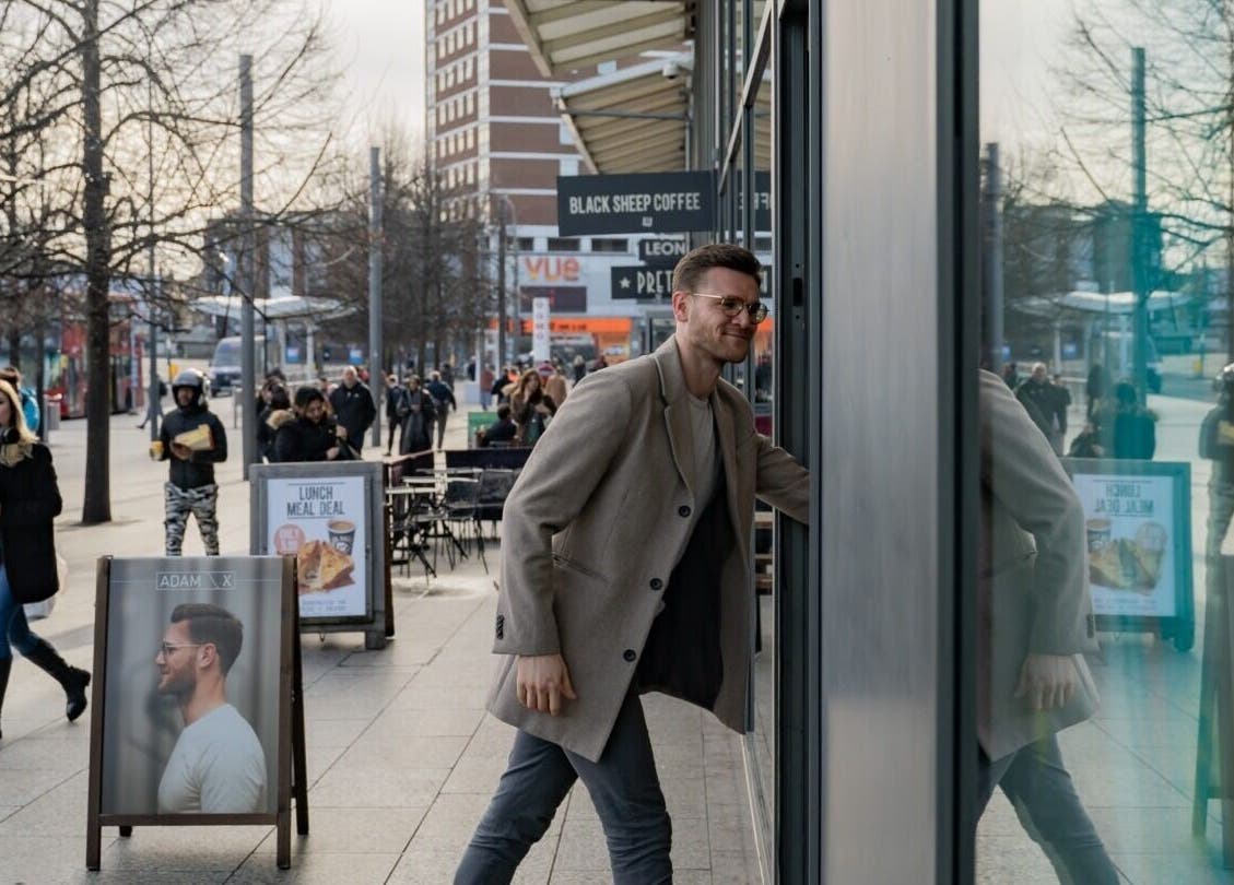 Man entering ADAM Grooming Atelier - Westfield London, located in London, England, GB.