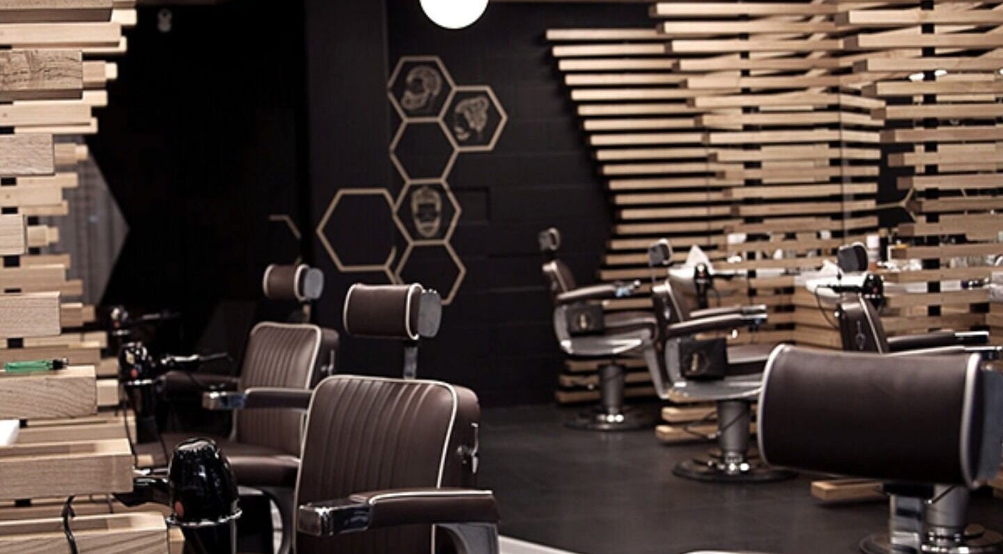 Modern interior of ADAM Grooming Atelier - Fitzrovia, London, England, GB, featuring sleek barber chairs.