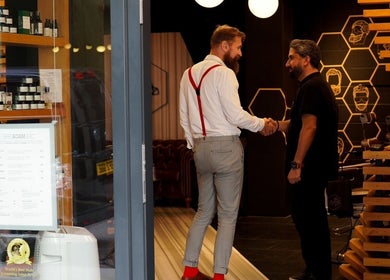 Reception area of ADAM Grooming Atelier - Fitzrovia in London, England, GB, showcasing a welcoming handshake.