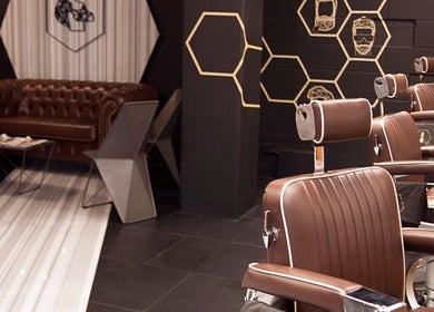Interior of ADAM Grooming Atelier - Fitzrovia, London. Classic brown leather chairs and decor.