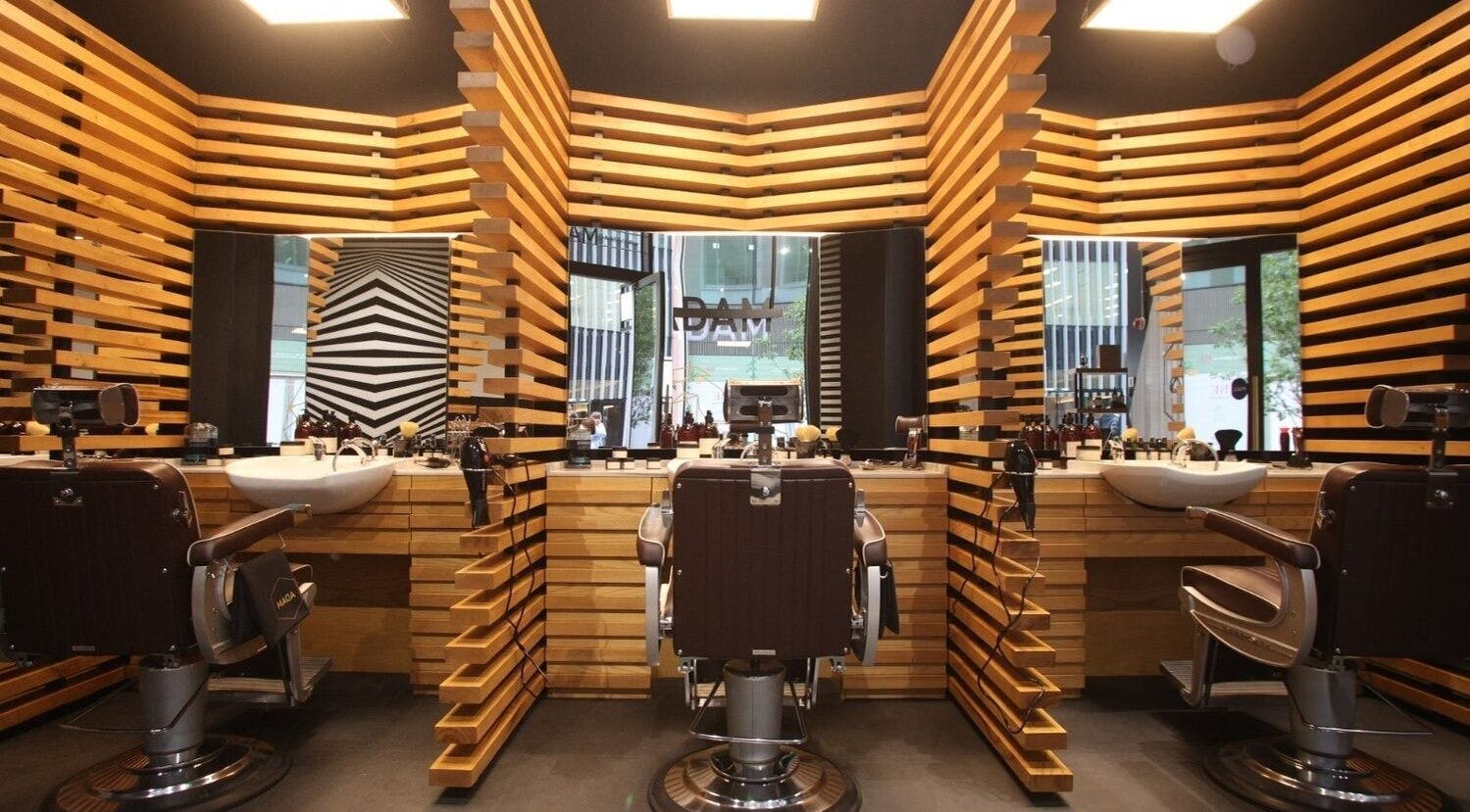 Chic interior of ADAM Grooming Atelier - Victoria in London, England, GB featuring sleek wooden accents.