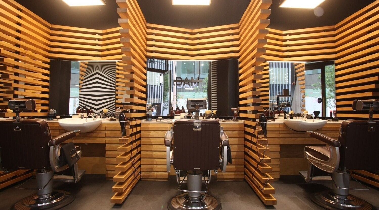Chic interior of ADAM Grooming Atelier - Victoria in London, England, GB featuring sleek wooden accents.