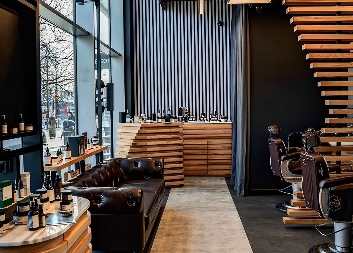 Sleek interior of ADAM Grooming Atelier - Monument in London, England, GB showcasing luxury barber chairs and products.