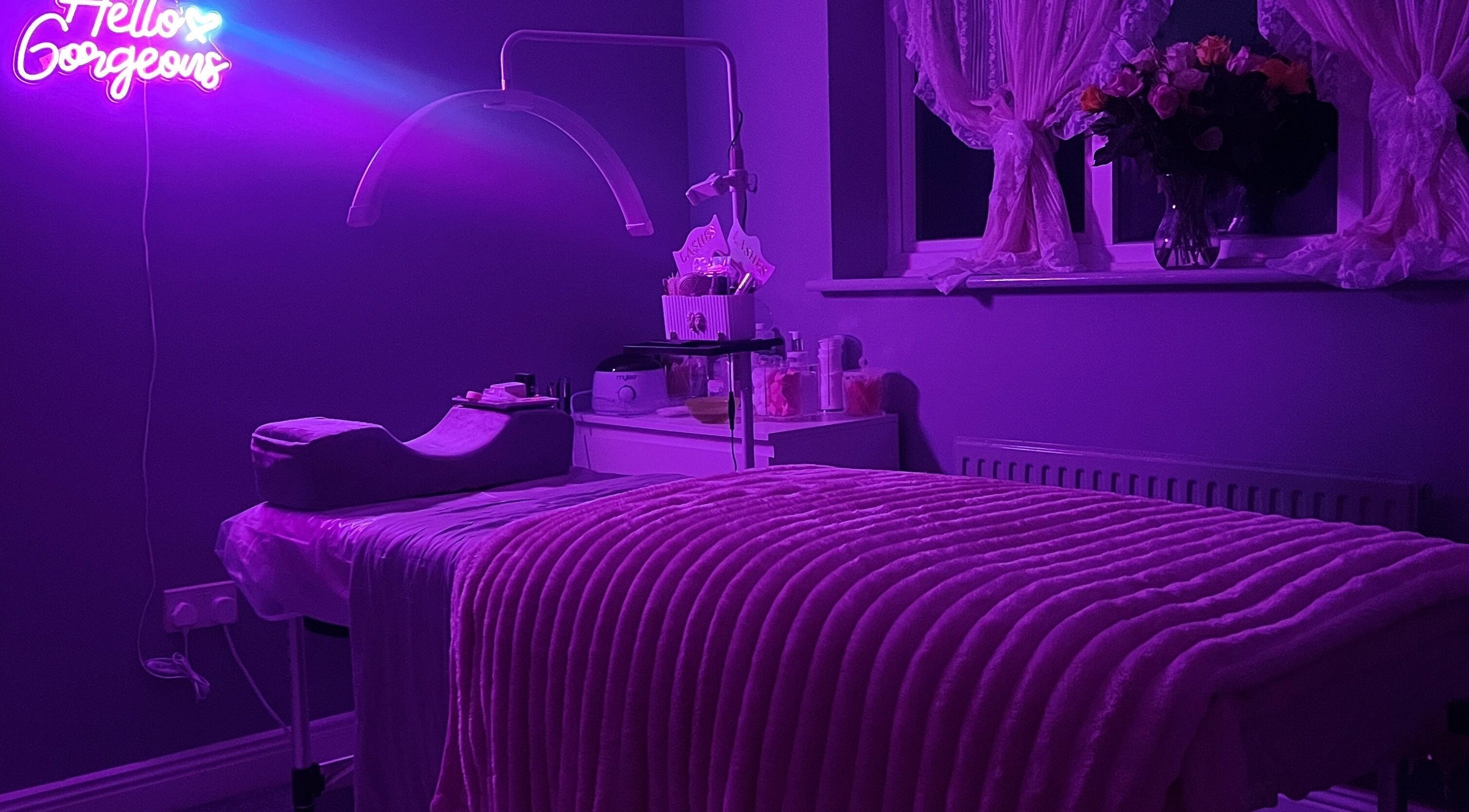 Relaxing beauty room at Faces Enhanced, Nottingham, England, GB with purple lighting and plush decor.