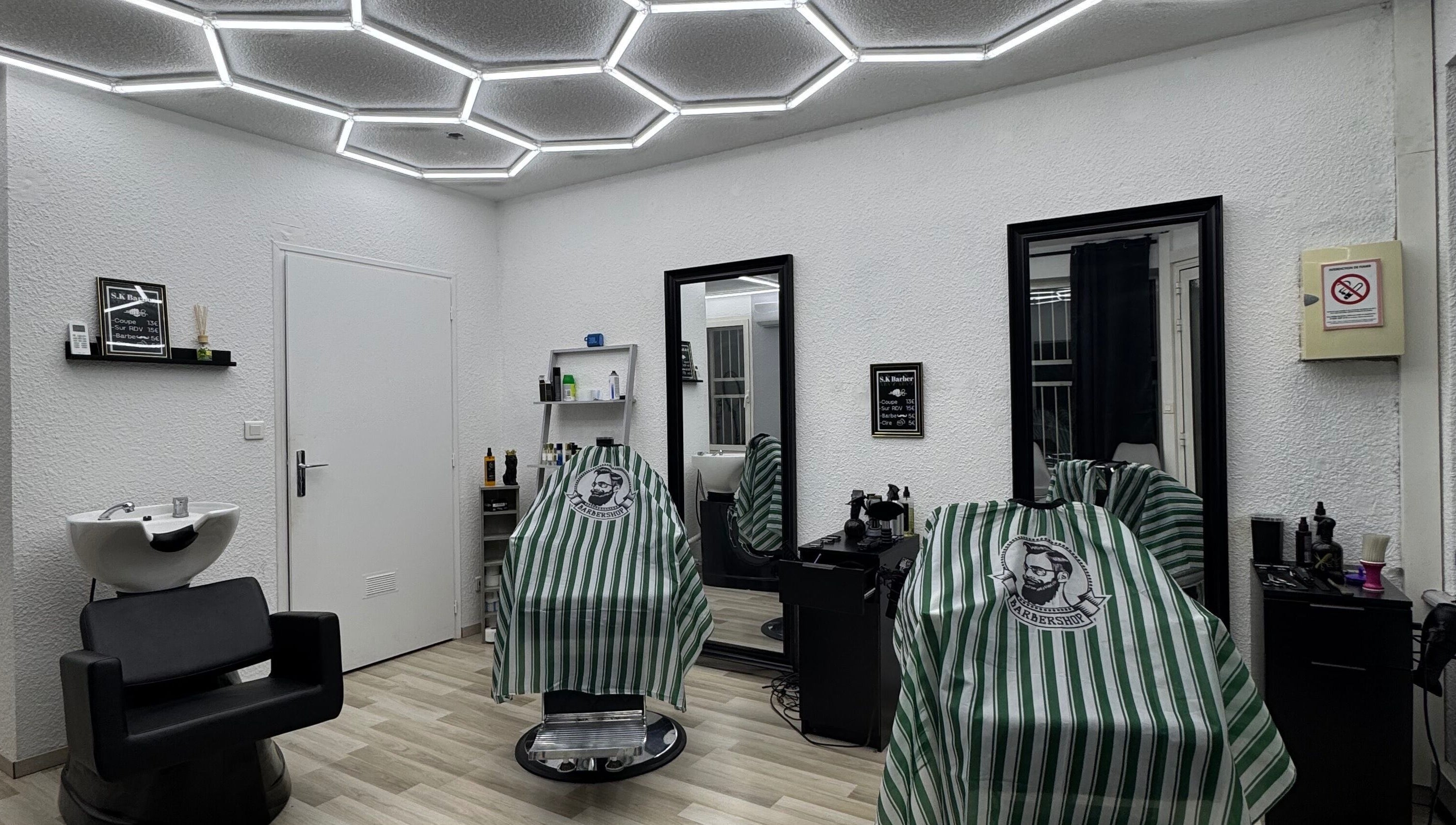 Intérieur élégant de Sk Barber à Perpignan, Occitanie, FR avec sièges et éclairage moderne.