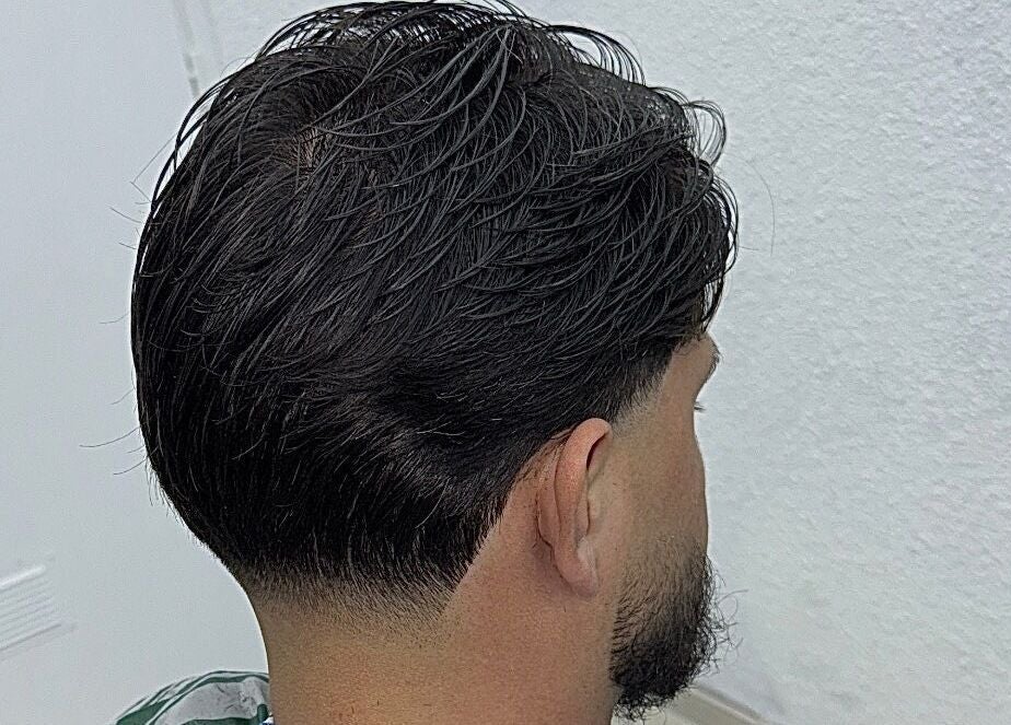 Coiffure homme moderne réalisée à Sk Barber, Perpignan, Occitanie, FR, mettant en valeur un dégradé soigné.