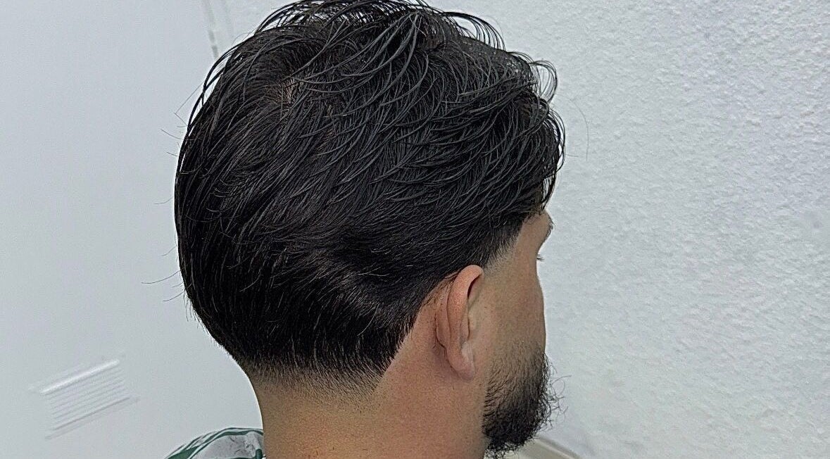 Coiffure homme moderne réalisée à Sk Barber, Perpignan, Occitanie, FR, mettant en valeur un dégradé soigné.