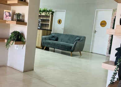 Elegant lounge area at Beauty By Kelly, Boksburg, Gauteng, ZA with a plush gray sofa and modern decor.