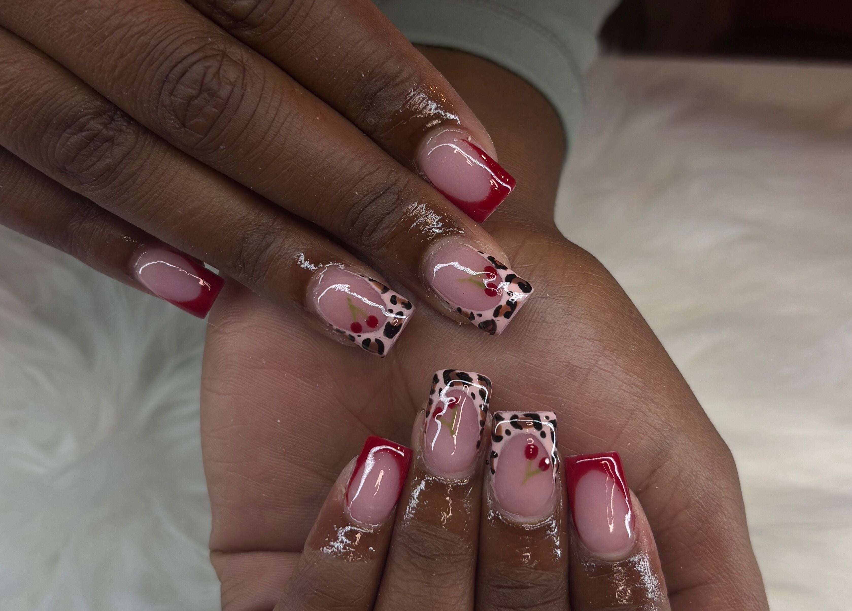 Stylish nail art at Certified Lover Nails in Mitcham, England, GB featuring red tips and floral accents.