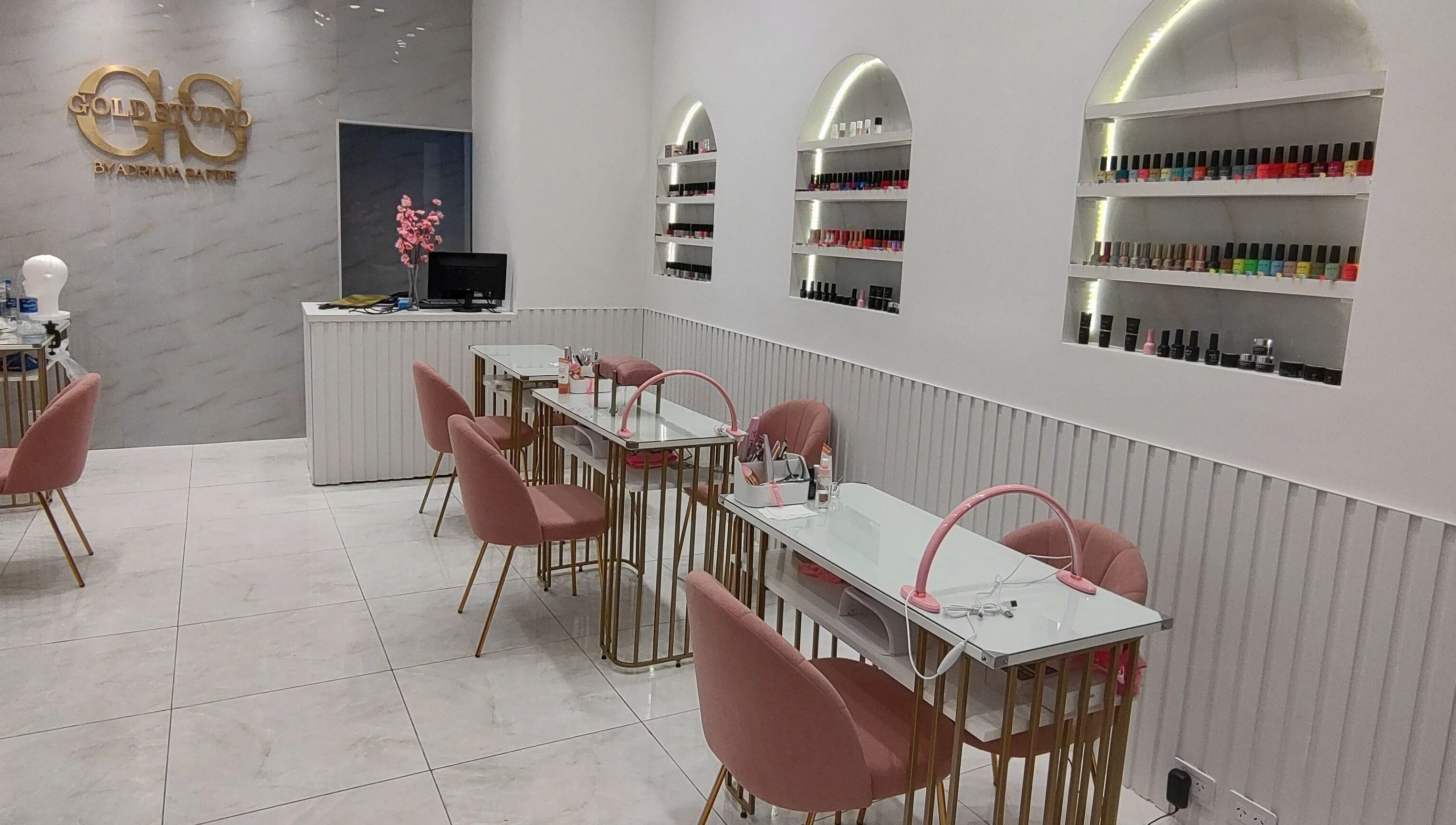 Espacio de manicura en Gold Studio, Buenos Aires, Ciudad Autónoma De Buenos Aires, AR con sillas rosas y estanterías.