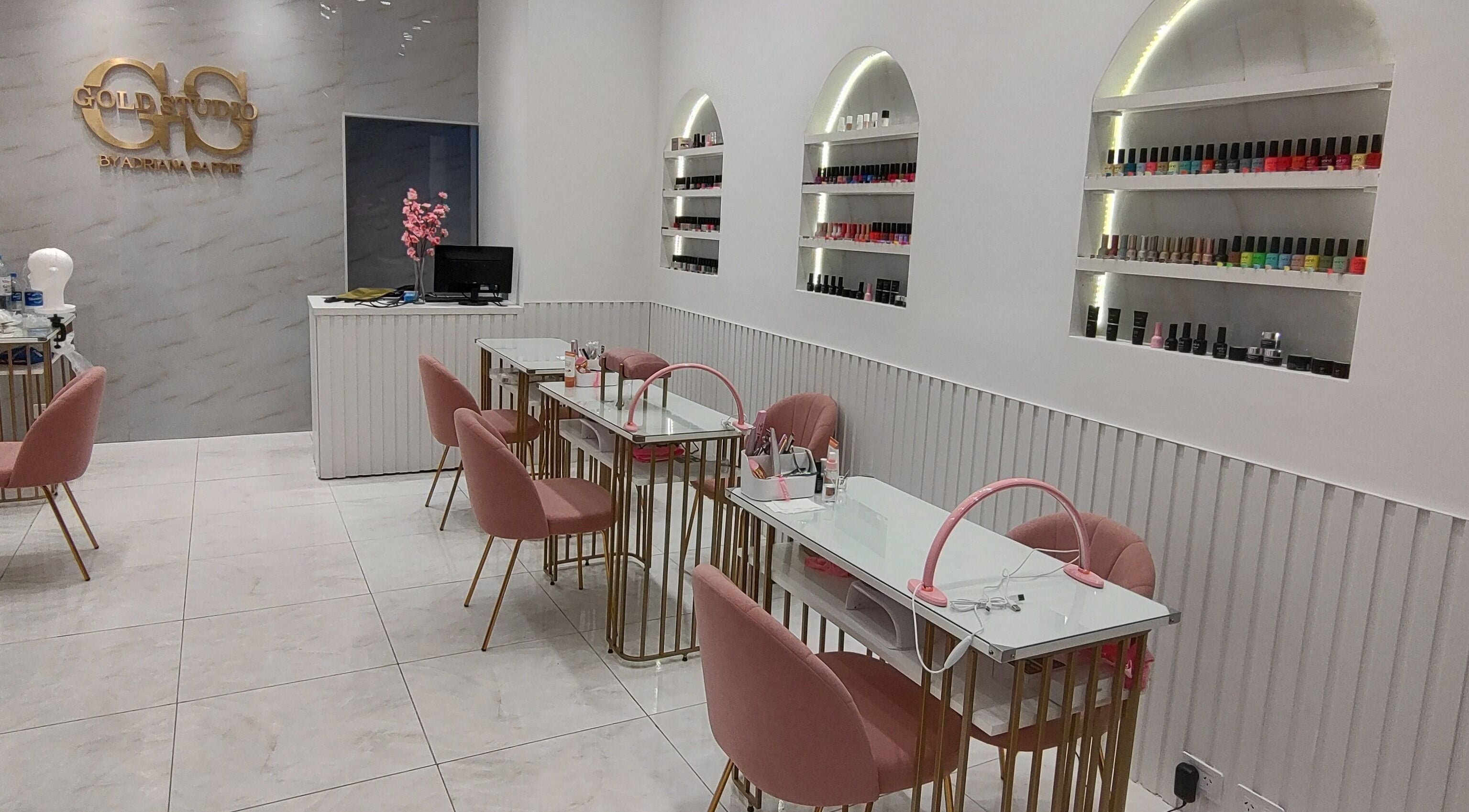 Espacio de manicura en Gold Studio, Buenos Aires, Ciudad Autónoma De Buenos Aires, AR con sillas rosas y estanterías.