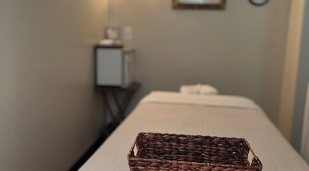 Massage room at Relax Thai Spa in Redondo Beach, California, US with a cozy bed and basket.