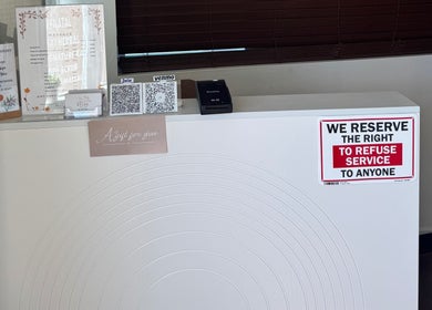Reception counter at Relax Thai Spa, Redondo Beach, California with service policies and payment options displayed.