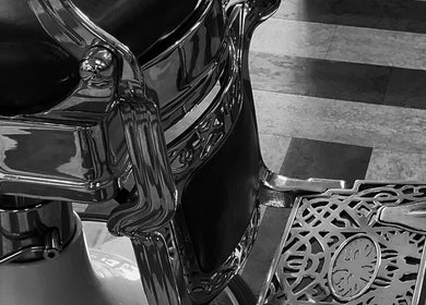 Antique barber chair detail at Slick Society, Chester, England, GB with intricate metalwork and leather seat.