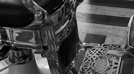 Antique barber chair detail at Slick Society, Chester, England, GB with intricate metalwork and leather seat.