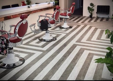 Elegant retro barber chairs at Slick Society, Chester, England, GB, showcasing modern geometric flooring.