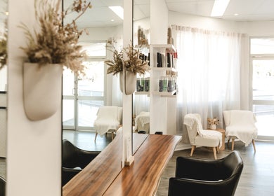 Chic interior of Paragon Hair, Belgian Gardens, Queensland, AU, featuring elegant chairs and natural decor.