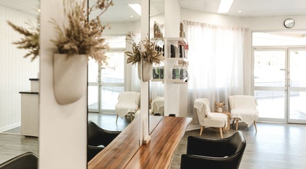 Chic interior of Paragon Hair, Belgian Gardens, Queensland, AU, featuring elegant chairs and natural decor.