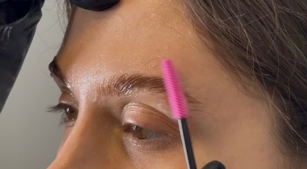 Brow grooming at OF.LAMIMANI, Chicago, Illinois, US. A professional uses a pink brush on eyebrows.